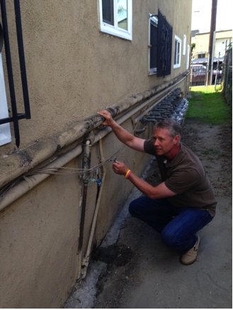 The author inspecting a leak in re-plumbing done many years prior
